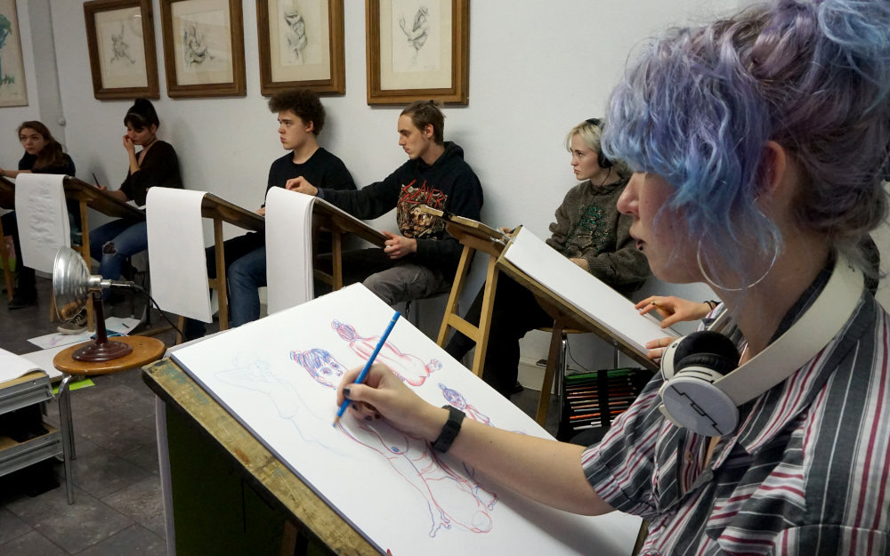 Aktzeichnen im Atelier: Schüler:innen an Zeichenböcken